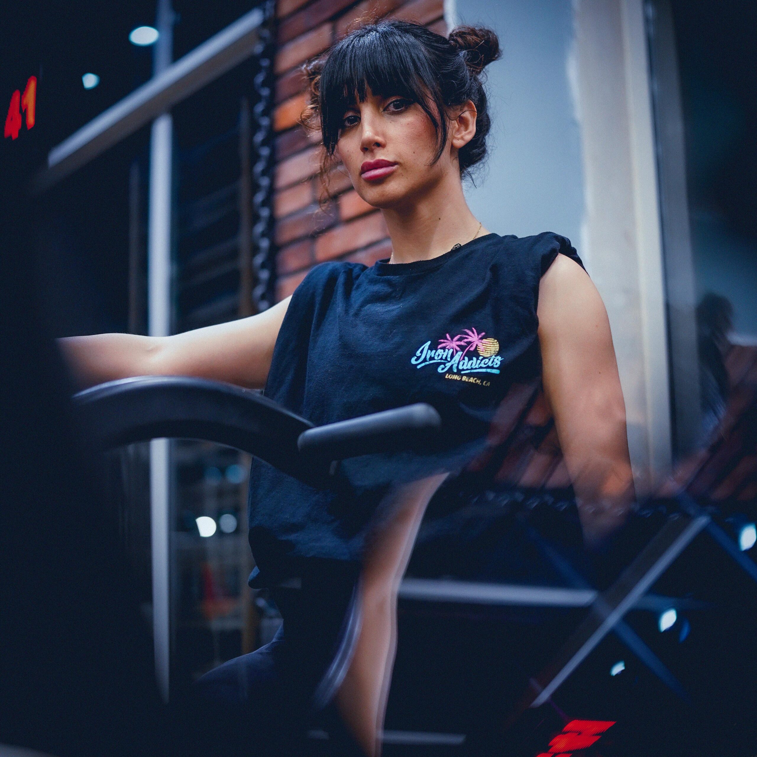 A fit woman posing confidently in a modern gym environment in Sulaymaniyah, Iraq.