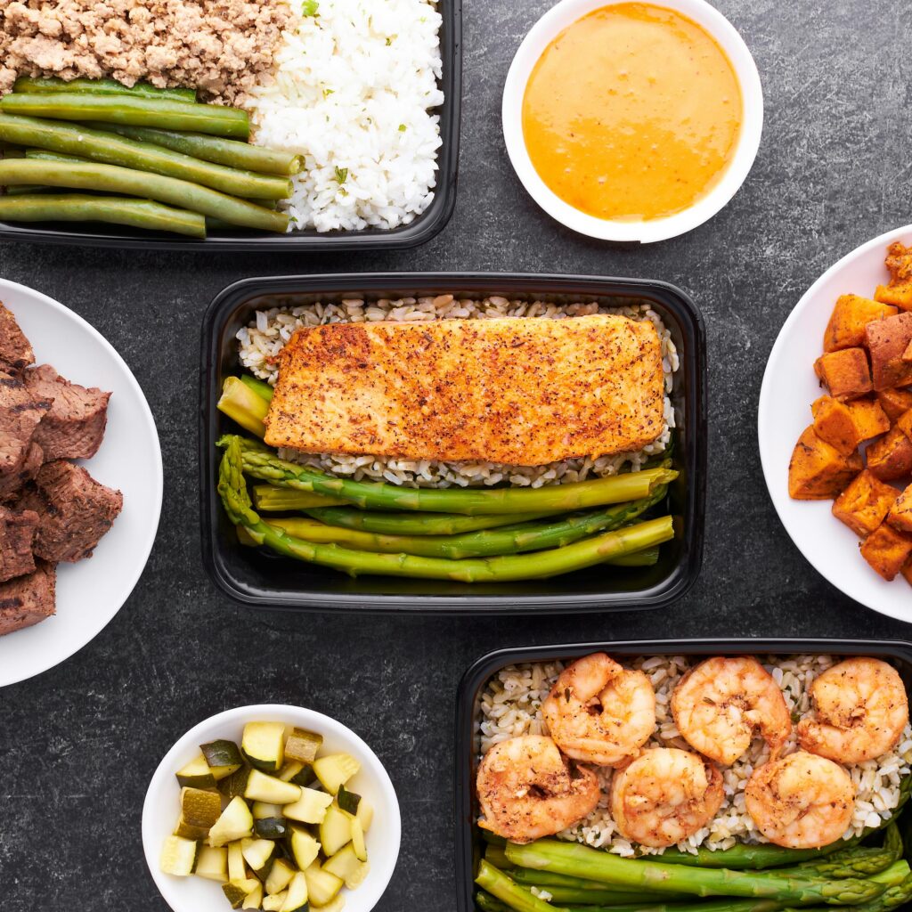 Linktree szablon 2 Assorted healthy meal prep with salmon, asparagus, shrimp, and rice, offering a balanced diet choice.