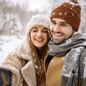 O mnie szablon 11 Happy couple in winter clothing, taking a selfie in a snowy outdoor setting.