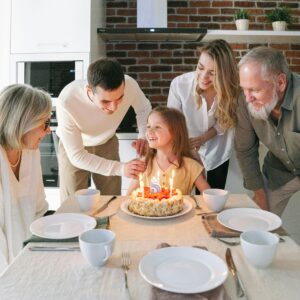 O mnie szablon 12 Family gathered indoors celebrating a young girl's birthday with cake and smiles.